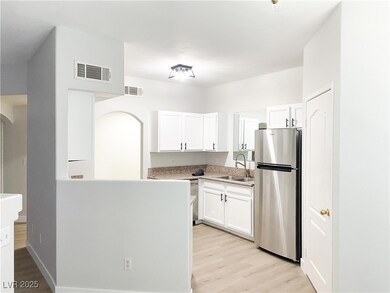 Kitchen featuring freestanding refrigerator, a sin