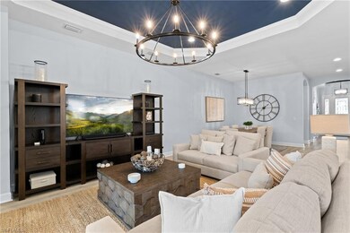 Living room featuring a tray ceiling, a chandelier
