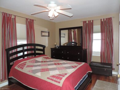 Master bedroom with hardwood floors and his/her cl
