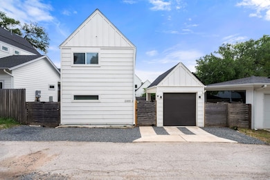 View of front of house featuring a garage, fence,