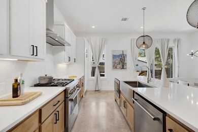 Kitchen featuring appliances with stainless steel finishes, concrete flooring, backsplash, wall chimney range hood, and recessed lighting