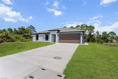 Prairie-style home featuring a front lawn, a garage, driveway, stucco siding, and cooling unit
