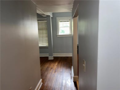 Corridor featuring dark wood finished floors and baseboards