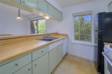 Kitchen with light countertops, pendant lighting,