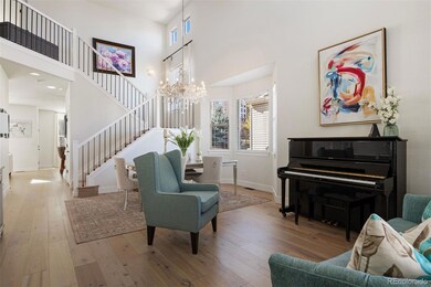 A welcoming great room crowned with soaring double-height ceilings, newly installed wide-plank hardwood floors, and sun-drenched windows that illuminate both the elegant dining area and inviting living space.