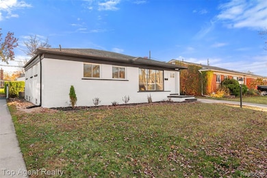 Ranch-style home featuring brick siding and a front lawn