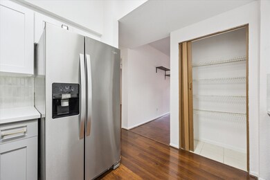 Kitchen includes a stainless steel refrigerator with water and ice dispenser, plus a spacious pantry with built-in shelving for ample storage.