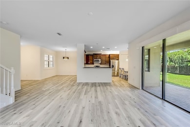 Unfurnished living room featuring light wood-type flooring, recessed lighting, and stairway