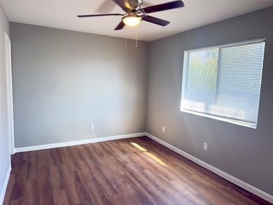 Spare room with wood finished floors and a ceiling fan