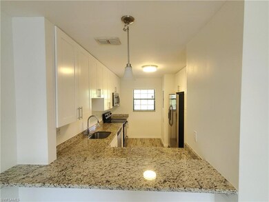 Kitchen featuring light stone countertops, light w