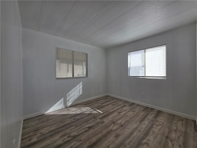 Empty room with wood finished floors and a textured ceiling