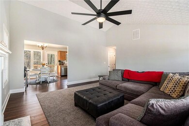 Living room featuring high vaulted ceiling, basebo