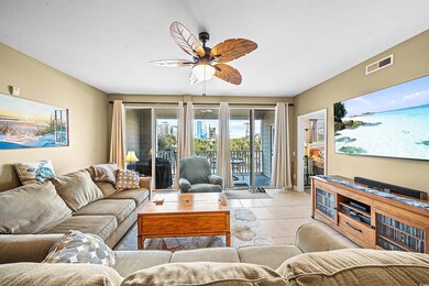 Living room with ceiling fan and light tile patter