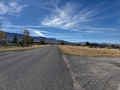 View of asphalt road featuring a mountain view and a view of rural / pastoral area