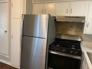 Kitchen featuring white cabinets, stainless steel fridge, and black range with gas stovetop