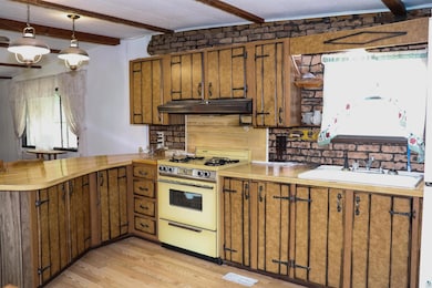 Kitchen featuring a peninsula, beam ceiling, white