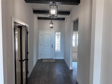 Foyer entrance with dark wood-style floors, beam c