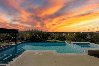 Pool at dusk with a pool with connected hot tub