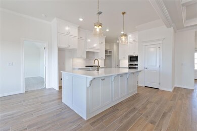 Kitchen with decorative light fixtures, white cabi
