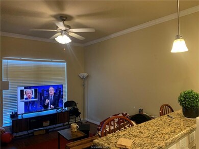 Living room featuring crown molding and ceiling fa