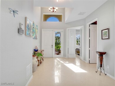 Tiled entrance foyer featuring an inviting chandel