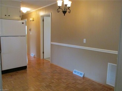 Parquet floors lead to three bedrooms.