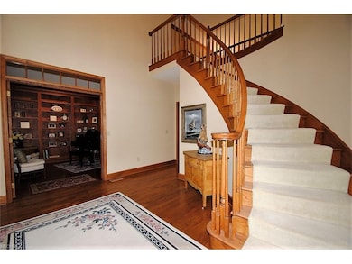 Sweeping staircase and french doors to dining room