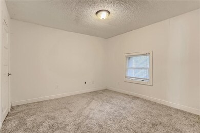 Carpeted spare room featuring a textured ceiling 