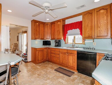 Ample counter and cabinet space with ceiling fan above .