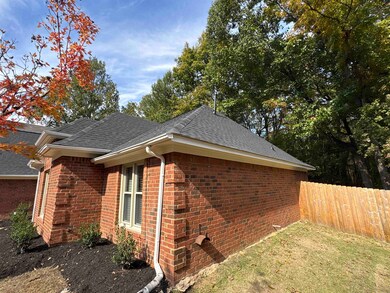 View of side of property featuring brick siding and roof with shingles