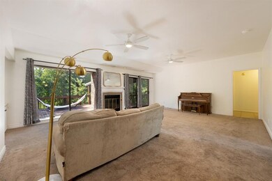 Carpeted living room with ceiling fan