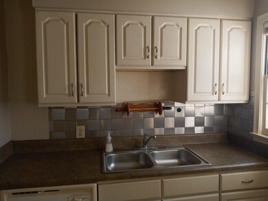 Kitchen featuring white cabinets, decorative backs