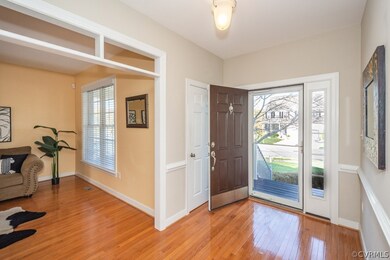 Foyer with wood floor and chair rail molding. Larg