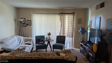 Carpeted living room with a textured wall