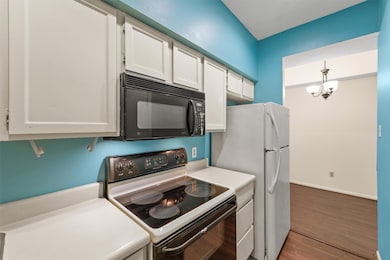 Cozy galley kitchen with crisp white cabinets and