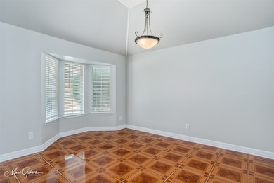 Unfurnished room featuring baseboards and vaulted ceiling