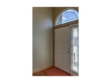 Arched window floods the entry with natural light