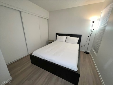 Bedroom featuring wood finished floors, a closet, and a textured ceiling