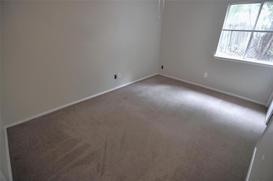Carpeted spare room with baseboards