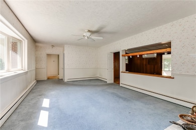 Carpeted empty room featuring ceiling fan, plenty