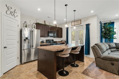 Kitchen with open floor plan, dark brown cabinets,