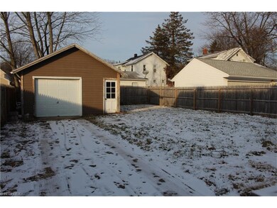 Driveway leading to garage and fenced in yard.