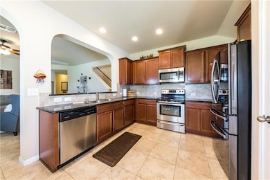 Kitchen featuring stainless steel appliances, tas