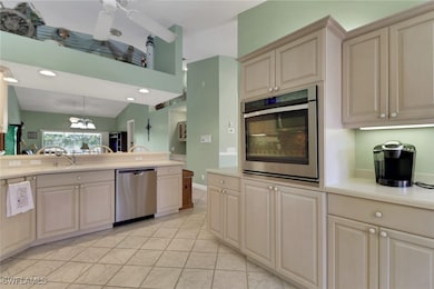 Kitchen with stainless steel appliances, decorative light fixtures, a chandelier, cream cabinetry, and ceiling fan