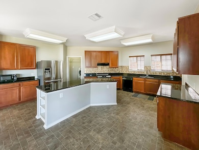 Kitchen with black appliances, extractor fan, a s