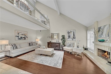 Elegant Formal Living Room with Wood Laminate Flooring, Fireplace, Dual Pane Windows, Plantation Shutters, Open Loft Above.