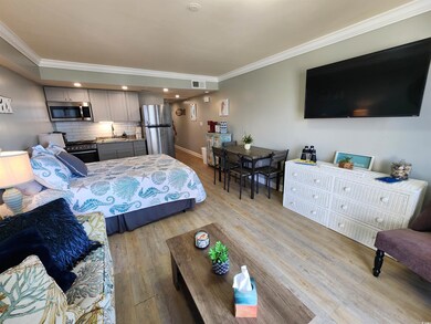 Bedroom with ornamental molding, freestanding refrigerator, light wood-style floors, and recessed lighting