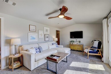 Living room featuring lofted ceiling and ceiling f
