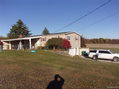 View of front facade with a front yard, a chimney, and an attached garage