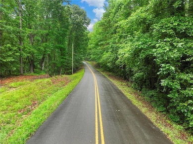 View of asphalt street featuring a forest view